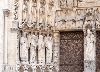 Detail of decorative marble statues carved around the entrance door of Notre Dame Cathedral in Paris