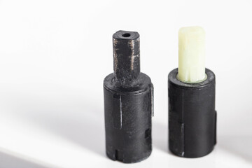 Black soft closes against a white toilet seat cover. Concept for replacing old, jammed soft closes with new ones, close-up. Copy space for text