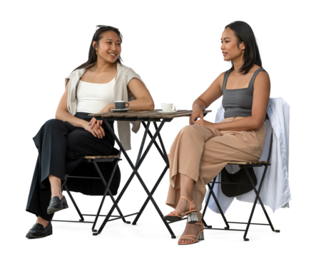 Two young Vietnamese women sitting in a cafeteria and talking, isolated on white and transparent background