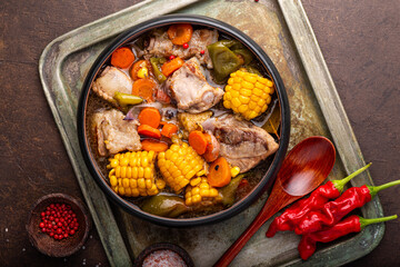 Chilean cuisine of Latin America. Traditional Chilean cazuela de cerdo. Pork soup with potatoes and corn, stew with corn and carrots top view
