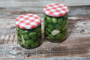 Preserving mexican sour gherkins in glass jars with garlic