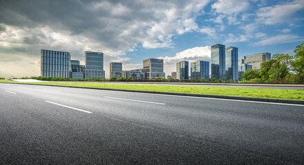 Modern Cityscape: Urban Architecture and Open Road Under Dramatic Sky