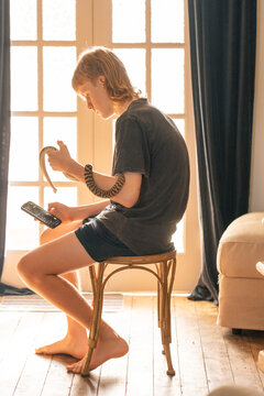 Adolescent boy using mobile phone while sitting indoors with pet snake
