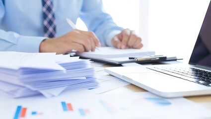 Businessman working with documents and laptop at office desk.