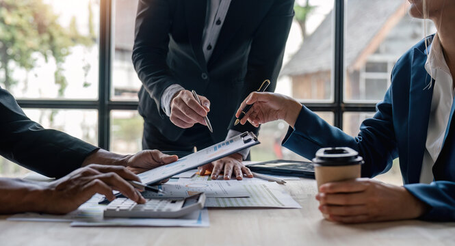 Analyst team in office analyzing financial data analysis for marketing strategy in office, dashboard paper format with graph and chart to optimize performance and management - Powered by Adobe