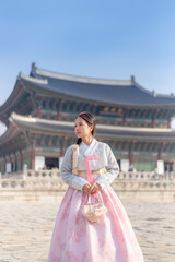 A woman in a traditional Korean hanbok stands gracefully at Gyeongbokgung Palace in Seoul, South Korea, blending history and culture in a timeless scene.”