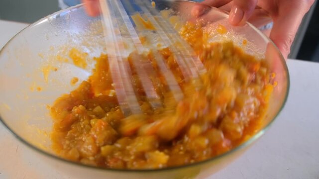 Woman chef hands whisking vegetables stew in bowl cooking on kitchen. Culinary techniques, homemade preparing healthy meal cook food dish, cuisine, seasoning garlic parsley greenery. Vegan food.