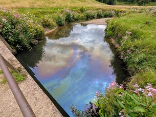 Oil pollution contaminating River Dean in Cheshire, England, UK.