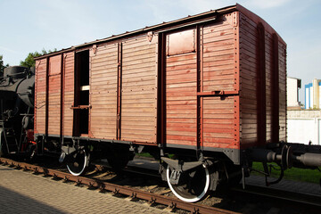 Historic wooden train car on display at a railway museum in the sunlight