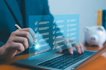 Businessman working on laptop with futuristic digital checklist interface, concept of task...