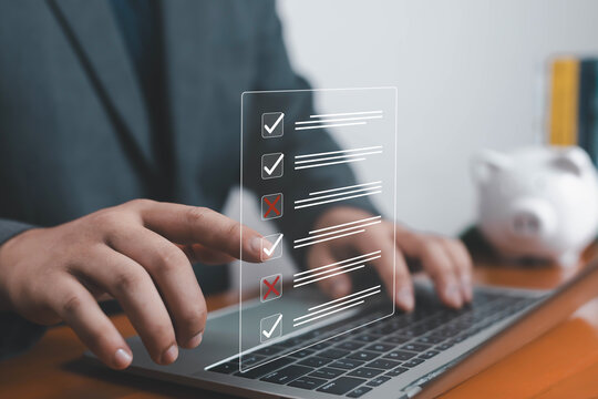 Businessman using laptop with digital checklist interface showing check marks and cross marks, concept of task management, productivity, progress tracking, goal setting, decision making. - Powered by Adobe