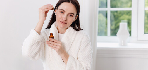 Woman enjoying a relaxing skincare routine in a modern bathroom at home
