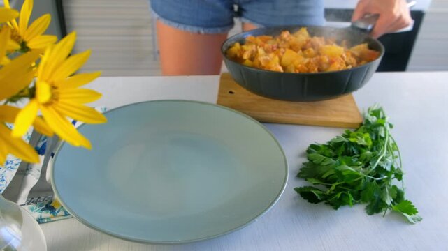 Woman serving steaming vegetables potatoes and chicken meat stew on plate on kitchen. Culinary techniques, homemade preparing healthy meal cook meat food, organic cuisine from fresh ingredients.