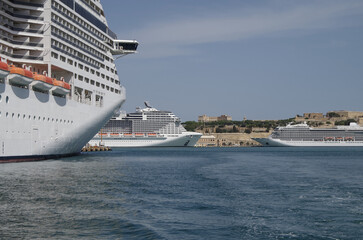 Modern cruise ship cruiseship liner being modernized over-hauled repaired refitted maintenanced by shipyard in Malta with dock and cranes
