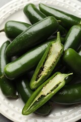 Ripe green jalapeno peppers on grey table, closeup