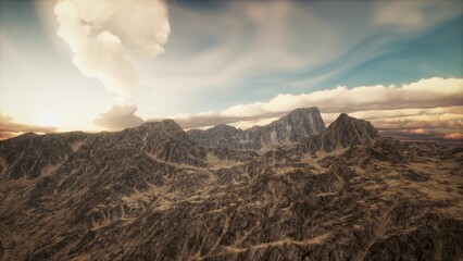 Golden light bathed the towering peaks as the sun began to set, creating dramatic shadows across the rugged terrain. Soft clouds danced above, enhancing the serenity of this majestic landscape.