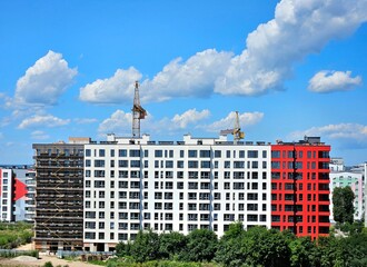 Aerial view of tower crane and concrete frame of high rise apartment buildings under construction in the city. Concept of urban development and real estate growth.