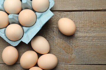 Raw chicken eggs on wooden table, top view. Space for text