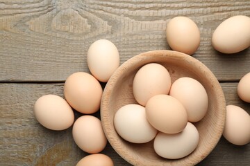 Fresh chicken eggs on wooden table, top view. Space for text