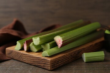 Fresh rhubarb stalks on wooden table, closeup