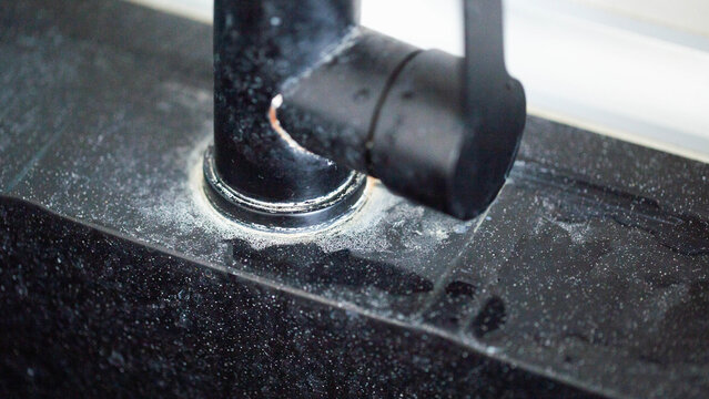 White scale from hard water on black bathroom faucets, industry