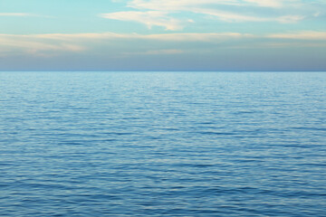 Obraz premium Tranquil seascape featuring gentle ripples and soft pastel hues that stretch to a distant horizon.