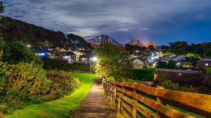 Forth Bridge standing over South Queensferry town at night