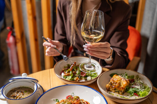 Woman toasting with white wine at Italian dinner