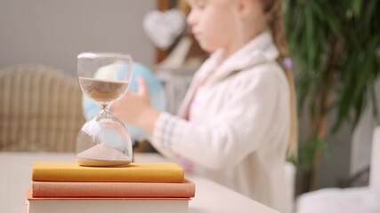 schoolgirl studies at home, girl Student learning geography with globe map, hourglass measuring time, global knowledge, back to school, Child homework, time management, Education and childhood - Powered by Adobe