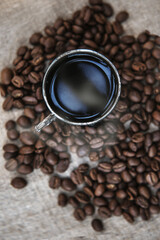 Black coffee in vintage silver cups on wooden background
