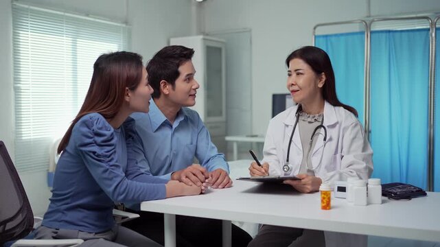 Doctor giving medical advice to a young couple in a hospital room