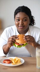 Woman eating a hamburger and fries