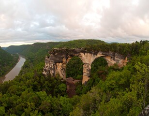 Panoramic view of a natural sandstone arch over a river valley