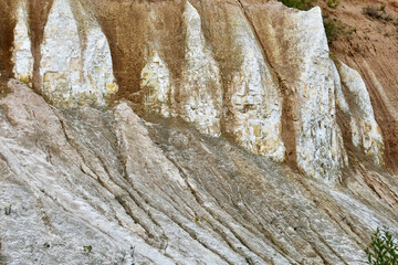 A chalky career with green trees. Chalk mountains, chalk mining. A relief chalky mountains.