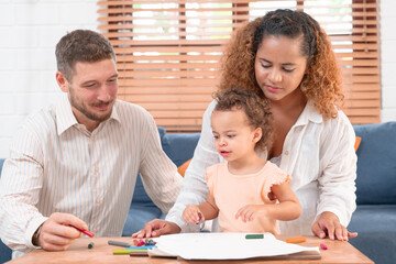 Happy parents playing with their adorable baby at home. Mom and dad looking at their baby who drawing on paper with pencil in cozy living room. Creative education. Early development