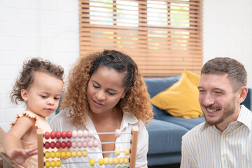 Happy family playing educational games with smiling children on living room table at home. Happy family playing with their kids on a weekend.