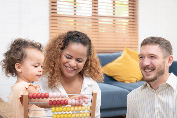 Happy family playing educational games with smiling children on living room table at home. Happy family playing with their kids on a weekend.