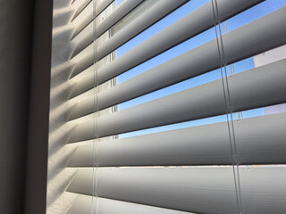 Close-Up of Open Window Blinds with Blue Sky