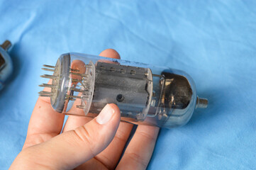 vintage vacuum tubes on blue background, retro electronic components used in radios and amplifiers,...