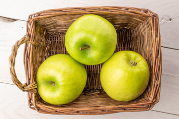 Green juicy apples on a wooden table, macro, top view.