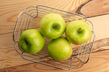 Green juicy apples on a wooden table, macro, top view.