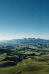 Expansive, blurred landscape view of rolling hills and valleys