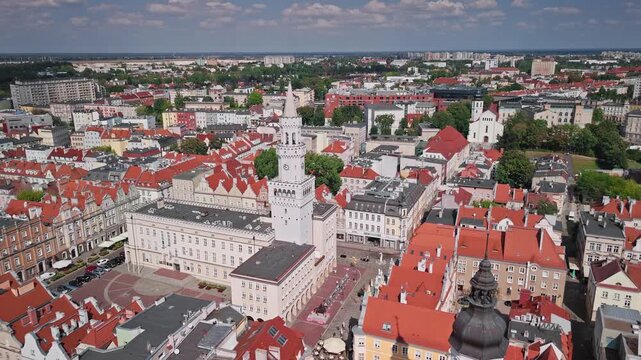 Aerial view of Market Square, showcasing the town hall's striking white tower, red-roofed buildings under a blue sky, Opole, Opole Voivodeship, Poland.