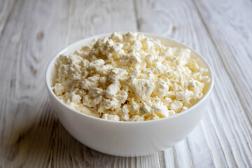 білий домашній сир у білій мисці