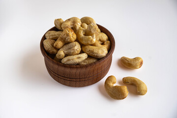 Raw peeled cashew nuts in a wooden bowl.