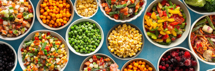 A variety of fresh vegetables frozen for winter, arranged on plates against a cool blue background, showcasing vibrant, seasonal produce ready for future meals, banner