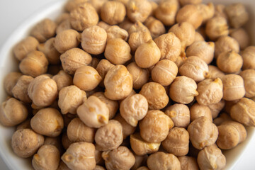 raw chickpeas in a bowl on a white background