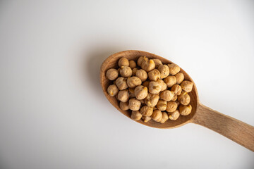 raw chickpeas on a spoon on a white background