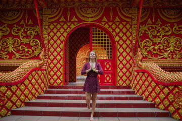 A Serene Moment of Meditation at a Vibrant Temple Surrounded by Intricate Red and Gold Designs Reflecting Cultural Heritage and Spirituality