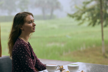 Contemplative Woman Enjoying Tea in a Serene, Misty Landscape Surrounded by Lush Greenery, Capturing the Essence of Tranquility in Nature